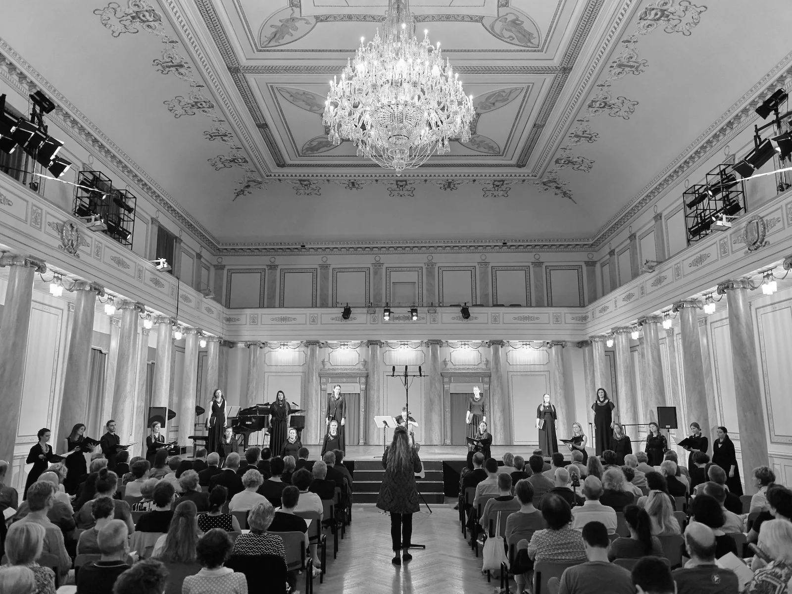 Black and White photo of the Vikra Chamber Choir performing in a theatre