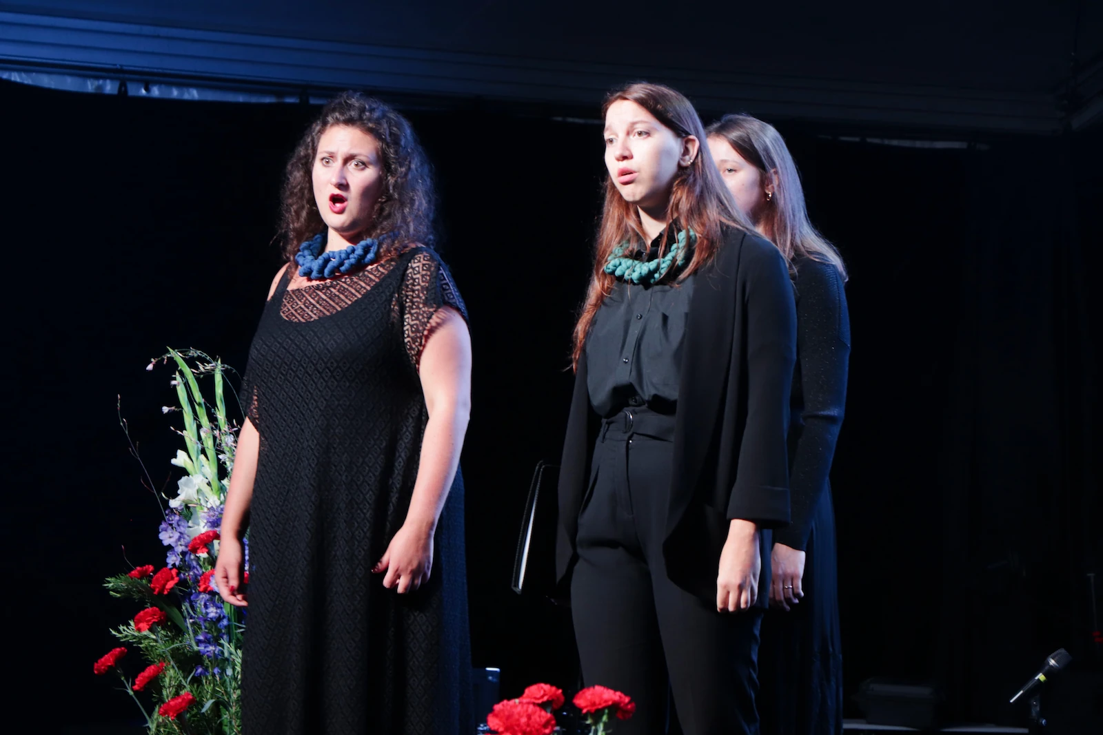 Three choir members from the Vikra Chamber Choir performing in Draga in 2023